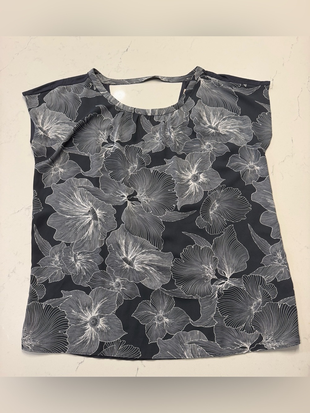 LOFT open-back cutout loose top featuring a charcoal gray and white floral line-